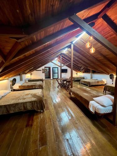 a large room with three beds and a wooden floor at Finca Premium en el Eje Cafetero in Ulloa