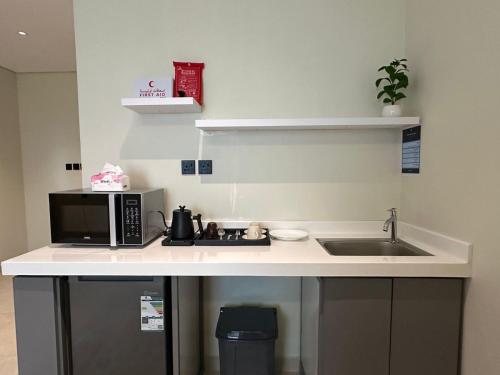 a kitchen counter with a microwave and a sink at Ambra 213 in Medina