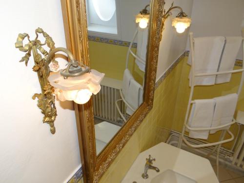 a bathroom with a mirror and a sink at La Villa L'Argentine in Cabourg