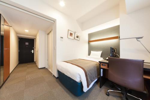 a hotel room with a bed and a desk at HOTEL MYSTAYS Sakaisuji Honmachi in Osaka