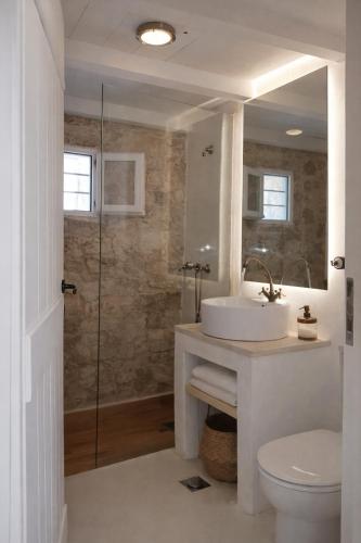 a white bathroom with a sink and a shower at Light & Stone Villa, Kefalonia in Lixouri