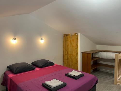 a bedroom with a pink bed with towels on it at L'Escapade Bourguignonne, à 10 minutes de Cluny, petit déjeuner inclus! in Clermain