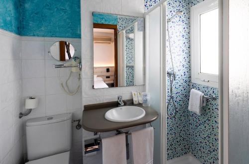 ein Badezimmer mit Waschbecken, Toilette und Spiegel in der Unterkunft Hotel Bersoca in Benicàssim