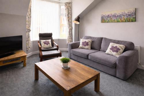 a living room with a couch and a coffee table at Cosy and convenient Sunderland apartment in Sunderland