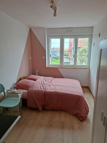 a bedroom with a large bed and a window at nid doré in Calais