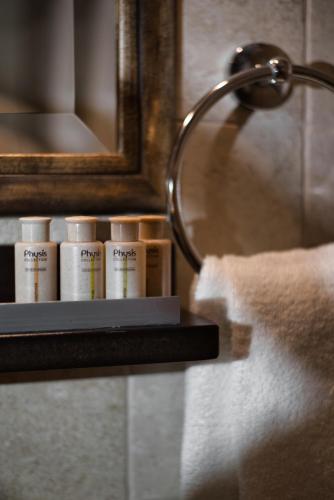 a shelf in a bathroom with a mirror and toiletries at Αρχοντικό Ταξίμι - Ανθέων Έμπνευση in Argalasti