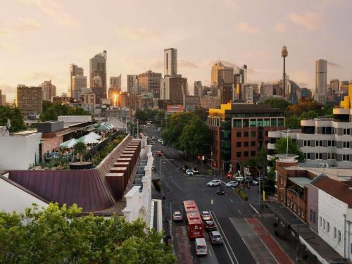 a view of a city street with buses and cars at 25hours Hotel Sydney The Olympia in Sydney
