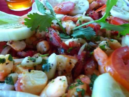 a plate of food with shrimp and tomatoes and parsley at Cabañas Zoh Laguna Calakmul in Xpujil