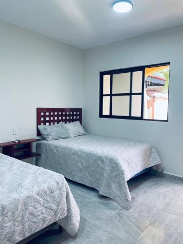 a bedroom with two beds and a window at Hotel Villa Chucum-Tikuch in Tikuch
