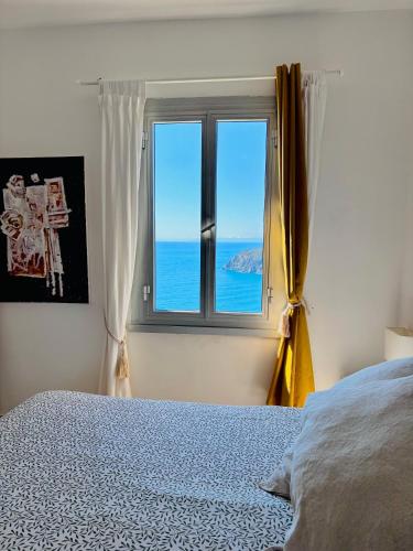 a bedroom with a window with a view of the ocean at Appartamento Moneglia Holidays in Moneglia