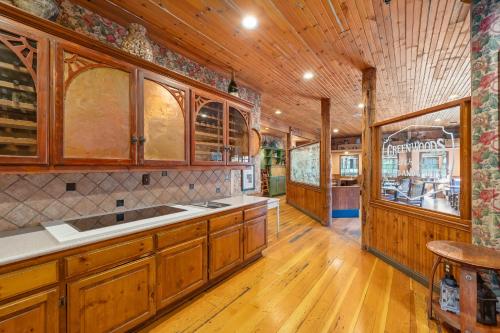 a kitchen with wooden cabinets and a wooden floor at Cambria Pines Lodge in Cambria