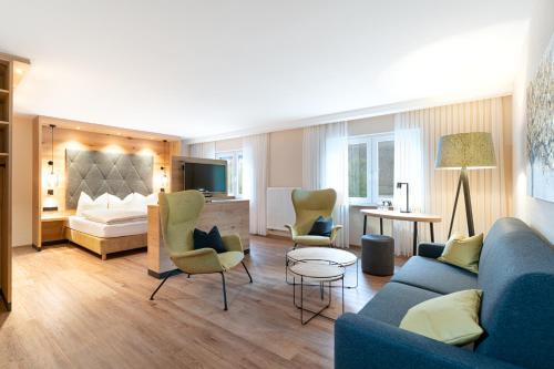 ein Wohnzimmer mit einem blauen Sofa und Stühlen in der Unterkunft Hotel Restaurant Pollmanns in Ernst