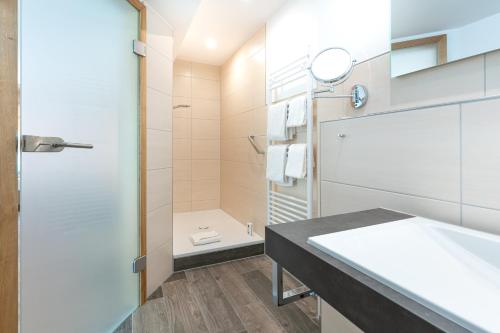 ein Badezimmer mit Dusche, Waschbecken und Toilette in der Unterkunft Hotel Restaurant Pollmanns in Ernst