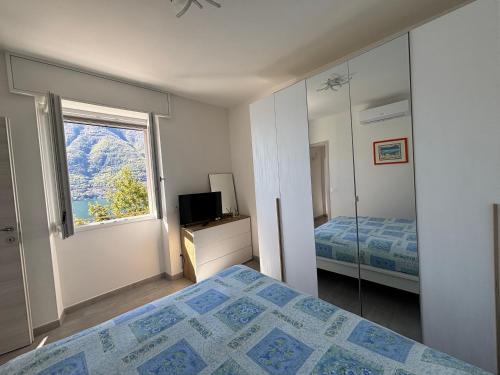 a bedroom with a bed and a mirror and a television at Como Lake Paradise vicino a Nesso e Bellagio in Pognana Lario