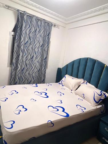 a bedroom with a bed with blue footprints on it at Studio meublé akwa in Douala