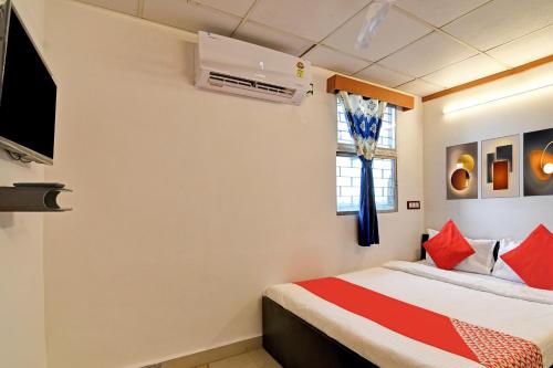 a bedroom with a bed with red pillows at Hotel O Jalan Regency in Kolkata