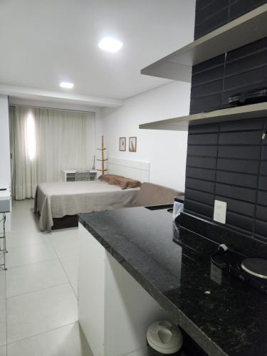 a bedroom with a bed and a kitchen with a counter at West Fit Padrão 05 in Mossoró
