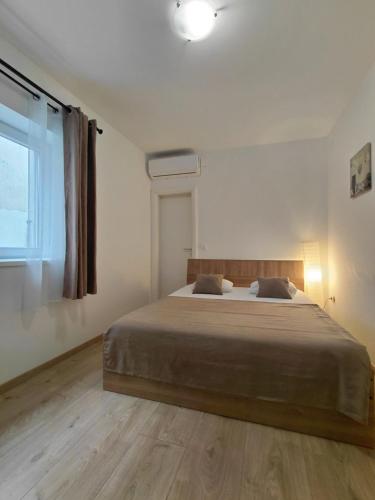 a bedroom with a large bed and a window at Apartments and room Maressa Centar in Vodice