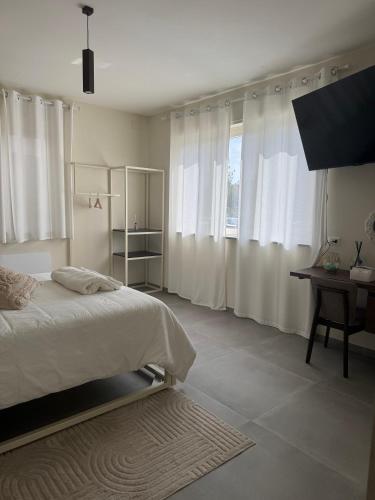 a bedroom with a bed and a desk and windows at Villa Perla in Battipaglia