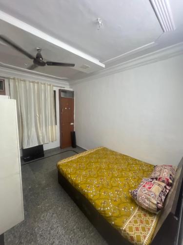 a bedroom with a bed with a yellow blanket at BEYOND INFINITY GROUP, pg in Navi Mumbai