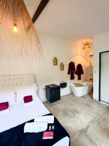 a bedroom with a bed and a tub and a sink at Studio Bali - Village Capixaba in Gravatá