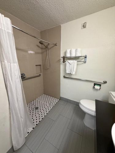 a bathroom with a shower curtain and a toilet at Everstay Living in Dallas