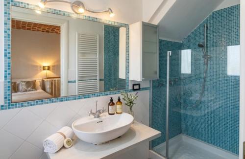 a bathroom with a sink and a shower and a mirror at le voltine in San Damiano dʼAsti