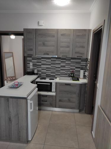 a kitchen with wooden cabinets and a stove top oven at Varkaris Room 3 in Katarráktis