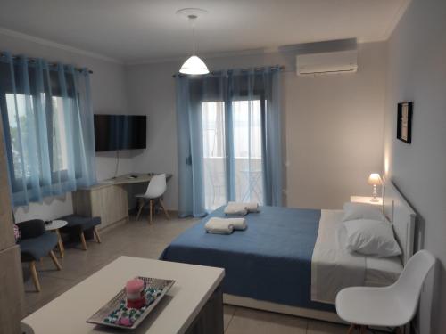 a bedroom with a blue bed and a living room at Varkaris Room 3 in Katarráktis