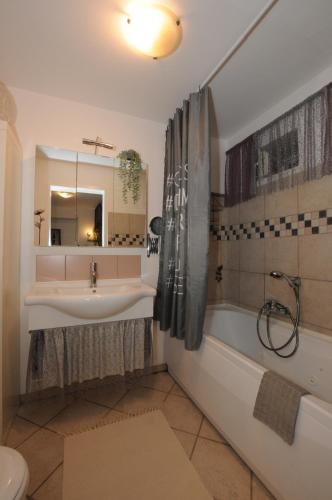 a bathroom with a sink and a tub and a toilet at Holiday House - Bella Nicol in Koper