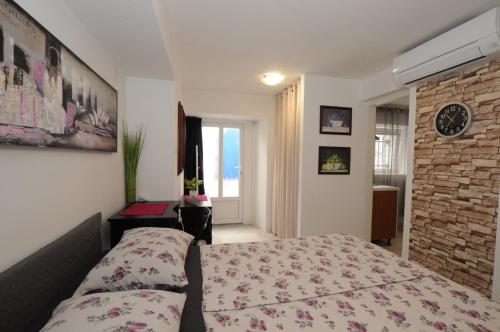 a bedroom with a bed and a brick wall at Holiday House - Bella Nicol in Koper