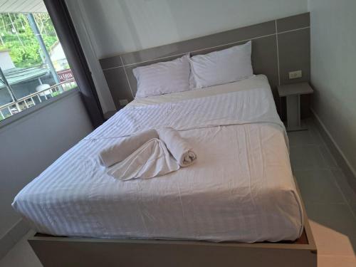 a bed with white sheets and a towel on it at SET INN restaurant & bar 1 & 2 in Kata Beach