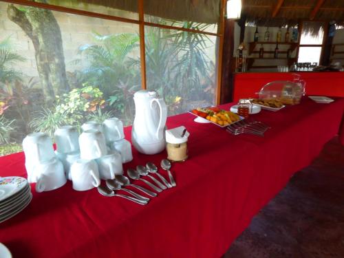 a table with a red table cloth with utensils on it at Cabañas Zoh Laguna Calakmul in Xpujil