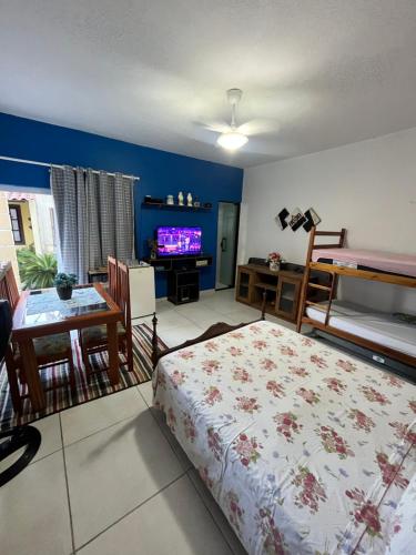 a bedroom with a bed and a table and a tv at Suíte aconchego in Cabo Frio