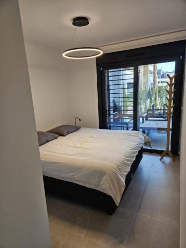 a bedroom with a large bed with a large window at Flamenca Village Resort apt 455 in Orihuela Costa