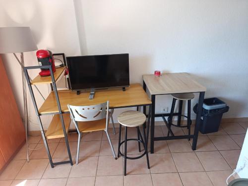 a desk with a computer monitor and two chairs at Le condo douillet d'Avignon in Avignon
