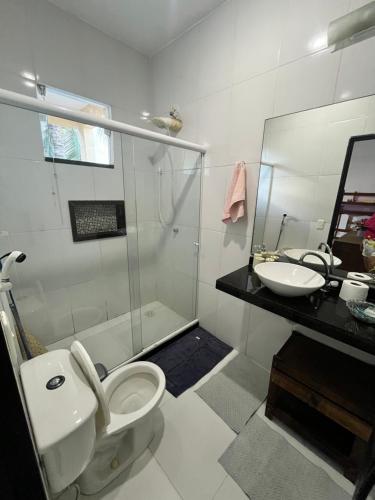 a bathroom with a shower and a toilet and a sink at Suíte aconchego in Cabo Frio