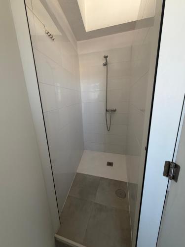 a shower with a glass door in a bathroom at Albergue Porta Real NO BIKE STORAGE in Santiago de Compostela