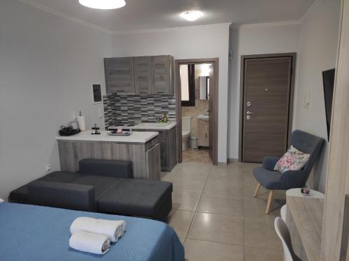 a bedroom with a bed and a kitchen and a chair at Varkaris Room 2 in Katarráktis