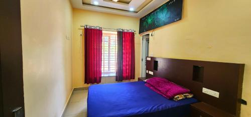 a bedroom with a blue bed and red curtains at Roca vista villaas vagamon in Vagamon
