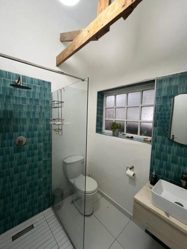 a bathroom with a toilet and a glass shower at The Red door cottage in Pretoria