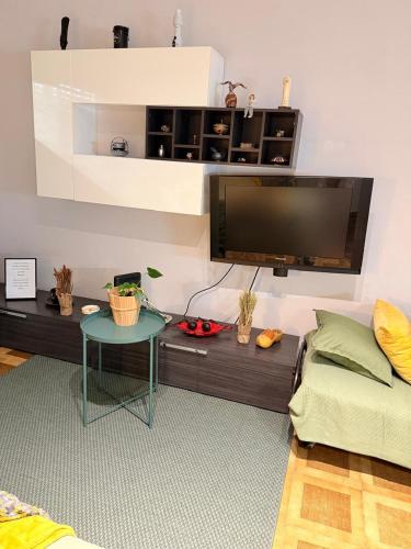 a living room with a table and a flat screen tv at Apartamento Centro Amadora in Amadora
