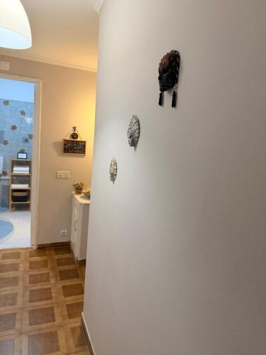 a room with a white wall with decorations on it at Studio Central na Amadora, Vista da Cidade, Sossegado, a 15min de Lisboa in Amadora
