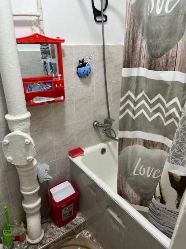 a bathroom with a shower curtain that says love at Flat in mountains in Yangiobod