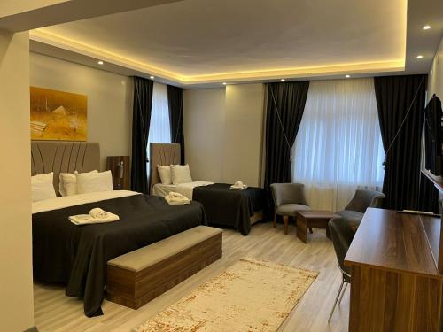 a bedroom with two beds and a living room at Grand Krone Hotel in Çınarcık