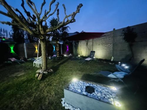 a backyard at night with a tree and a dog bed at Casa Les Ponts de Cé in Les Ponts-de-Cé