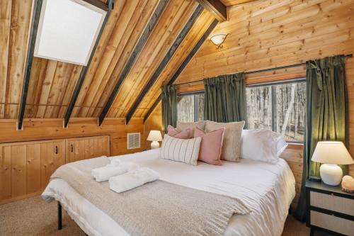 a bedroom with a bed in a log cabin at Dog-Friendly A-Frame with Hot Tub and Firepit in Hedgesville