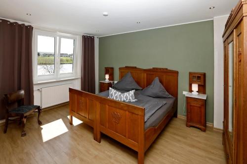 a bedroom with a large bed and a window at Apartment MOSELGARTEN - ÜberSchwang in Piesport