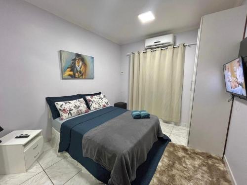 a bedroom with a bed and a television in it at Hotel Residencial Manaus - Flores in Manaus