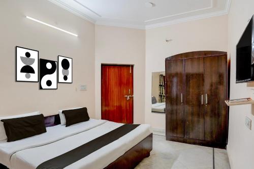 a bedroom with a large bed and a red door at Hotel O Hotel Brijwasi in Lucknow